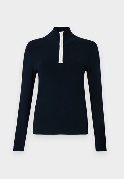 Μπλε ναυτικό μπλουζάκι με μακριά μανίκια, φερμουάρ μήκους τετάρτου και αντίθετο κρεμ φερμουάρ. Μαλακό, λείο ύφασμα και εφαρμοστή σχεδίαση.