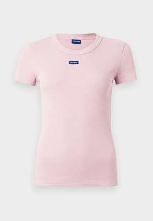 Camiseta rosa claro acanalada con cuello redondo, mangas cortas y un pequeño logo azul "HUGO" centrado en el pecho. Textura de tela suave.