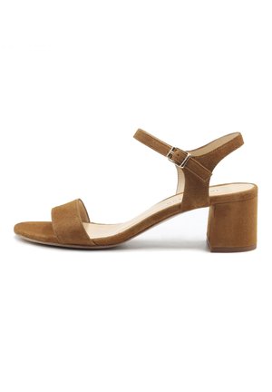 Braune Wildleder-Sandalette mit offenem Zehenbereich, Blockabsatz und verstellbarem Knöchelriemen mit silberner Schnalle, von der Außenseite vor weißem Hintergrund dargestellt.
