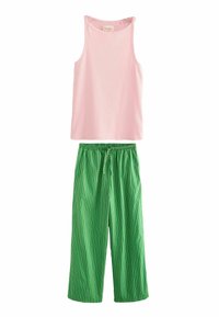 Rosa ribbet tanktop med brede stropper over grønne og hvide stribede brede bukser med elastisk talje og snor.