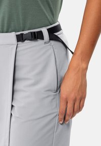 Graue Hose mit glatter Textur, ausgestattet mit einem schwarzen Gürtel und verstellbarem Schnallenverschluss, seitlichen Taschen und einer taillierten Passform.