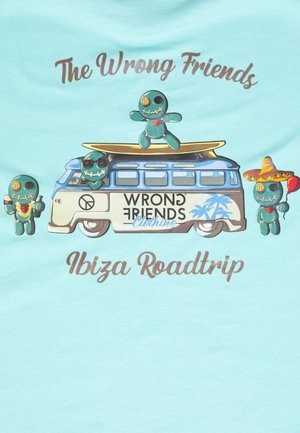 Un t-shirt bleu clair présente un graphisme d'un van vintage avec des personnages de style cartoon, le texte "The Wrong Friends Ibiza Roadtrip" et des accents colorés.