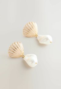 Orecchini in tono oro con accenti a forma di conchiglia e gocce simili a perle, caratterizzati da superfici bianche lisce e dettagli in oro testurizzati.