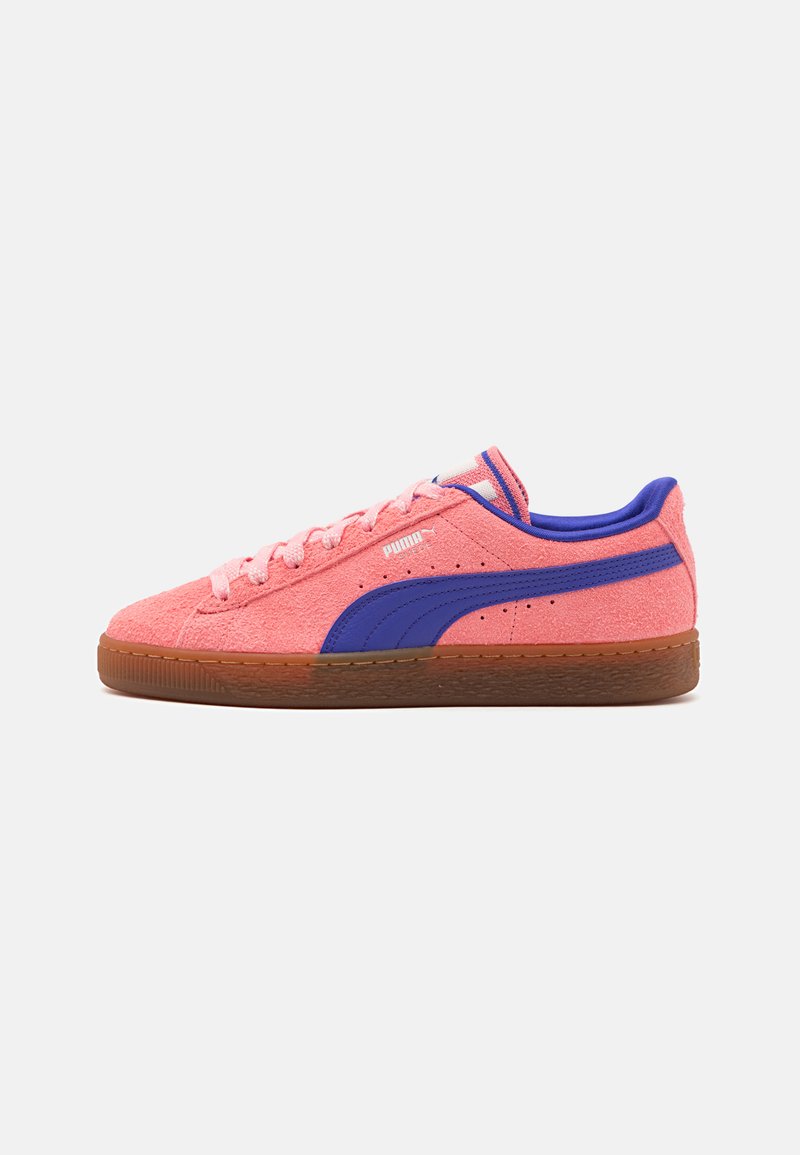 Rózsaszín velúr sneaker, lila csíkkal, barna gumitalppal és hozzá illő fűzőkkel. Oldalnézet, amelyen a logó és a texturált mintázat látható.