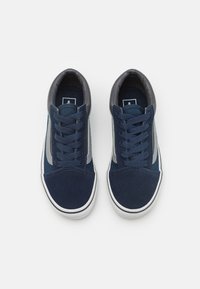 Zapatillas de ante azul marino con acentos grises, puntera redonda y suela de goma blanca. Presentan cordones planos y un collar acolchado para mayor comodidad.
