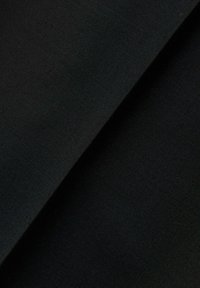 Tessuto nero con una texture liscia, che mostra una superficie leggermente lucida. Il materiale è leggero, piegato per mostrare profondità e caduta.