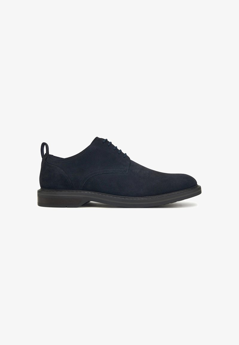 Scarpe eleganti in suede blu navy con profilo basso, suola in gomma e punta tonda. Presentano un sistema di allacciatura e un piccolo passante sul tallone.