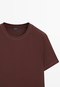 Effen korte mouw T-shirt met ronde hals in donkerbruine stof, zichtbare stiksels rondom de kraag en mouwen.