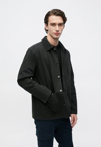 Μαύρο τζιν μπουφάν με γιακά από κοτλέ, κουμπωτό μπροστινό μέρος, πλαϊνές τσέπες και μία μόνο τσέπη στο στήθος. Λεία υφή, καθημερινός σχεδιασμός.