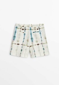 Shorts en mélange de lin couleur crème, présentant un motif tie-dye en bleu, vert et marron. Comprend deux poches arrière et une ceinture lisse.