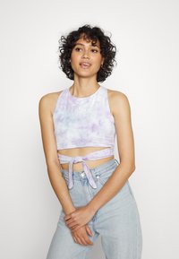 Top cropped tie-dye lavanda com decote redondo, parte da frente recortada e detalhe de laço lateral. Feito de um tecido macio e leve; marcação mínima visível.