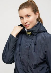 Marinblå vindjacka med huva, med zip-up framtill, snörningsdetaljer och en glänsande, slät textur. Lättviktsdesign som är idealisk för lager-på-lager.