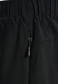 Zwarte sportbroek met een elastische tailleband, voorzien van een trekkoord en een ritsdetail aan de achterkant. Gladde textuur en lichtgewicht materiaal.