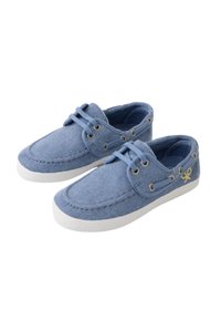 Par de zapatos casuales de lona azul con cordones, suelas blancas y logotipo amarillo en el lateral, sobre un fondo blanco.
