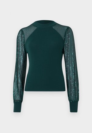 Teal topp med en tettsittende kropp og lange, gjennomsiktige ermer dekorert med paljetter, med rund hals og ribbede mansjetter.