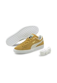 Puma sporta apavi sinepju dzeltenā zamšā ar baltu gumijas zoli un sānu svītru. Iekļauta papildus baltu šņoru pāris.