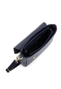 Granatowa skórzana torebka z złotymi elementami, otwieraną klapką, regulowanym paskiem i wieloma zapinanymi na zamek przegrodami wewnątrz.