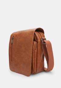 Brown faux leather shoulder bag with a flap, features a front zipper pocket, adjustable strap, and rectangular shape with textured finish.