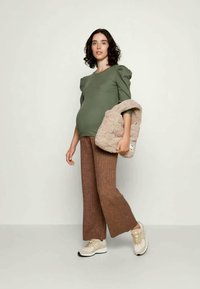 Roheline puff-sleeve tops, pruunad laia säärega püksid, beežid tossud ja tekstuuriga beež kott käepidemega. Pehme kangas, mugav istuvus.