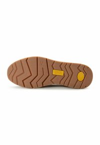 Brun gummisål til sneakers med et zigzag-mønster og en gul logo-plade med et soldesign i midten.