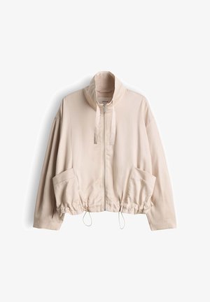Hellbeige Jacke mit Reißverschluss, hohem Kragen, langen Ärmeln, großen Fronttaschen und verstellbaren Kordelzügen am Saum.