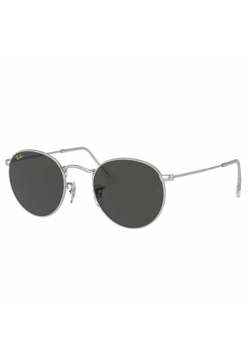 Occhiali da sole con una sottile montatura in metallo argentato, lenti scure di forma rotonda, supporti per il naso regolabili e un design minimalista. Logo Ray-Ban vicino alla lente.