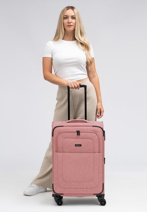 Roze stoffen koffer met een textuurafwerking, twee ritsen, een uittrekbare handgreep en vier wielen voor gemakkelijke mobiliteit.