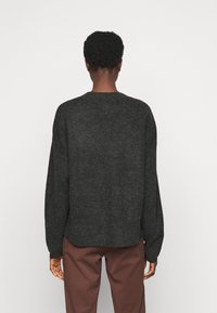 Dunkelgrauer Strickpullover mit langen Ärmeln, Rundhalsausschnitt und lockerer Passform. Merkmale sind gerippte Bündchen und ein leicht verjüngter Saum.
