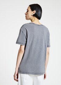 Gray, oversized t-shirt with a crew neckline, distressed edges, and short sleeves. The fabric appears soft with a faded finish.