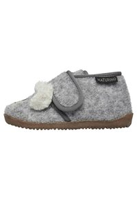 Zapatilla infantil de felpa gris con superficie texturizada, con un pom-pom de felpa, correa ajustable y suela de goma para mayor agarre.