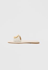 Slidesandal med en beige rem med geometrisk mønster, en rundet gul detalje på overdelen og en flad, lys sål.