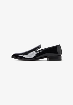 Chaussure slip-on en cuir verni noir avec un bout arrondi, une surface lisse et un petit talon carré, présentant des découpes latérales discrètes.