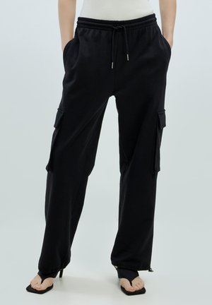 Schwarze leichte Cargo-Hosen mit einem elastischen Bund, seitlichen Taschen und Reißverschlüssen an den Säumen. Verfügt über ein lockeres Schnittdesign.
