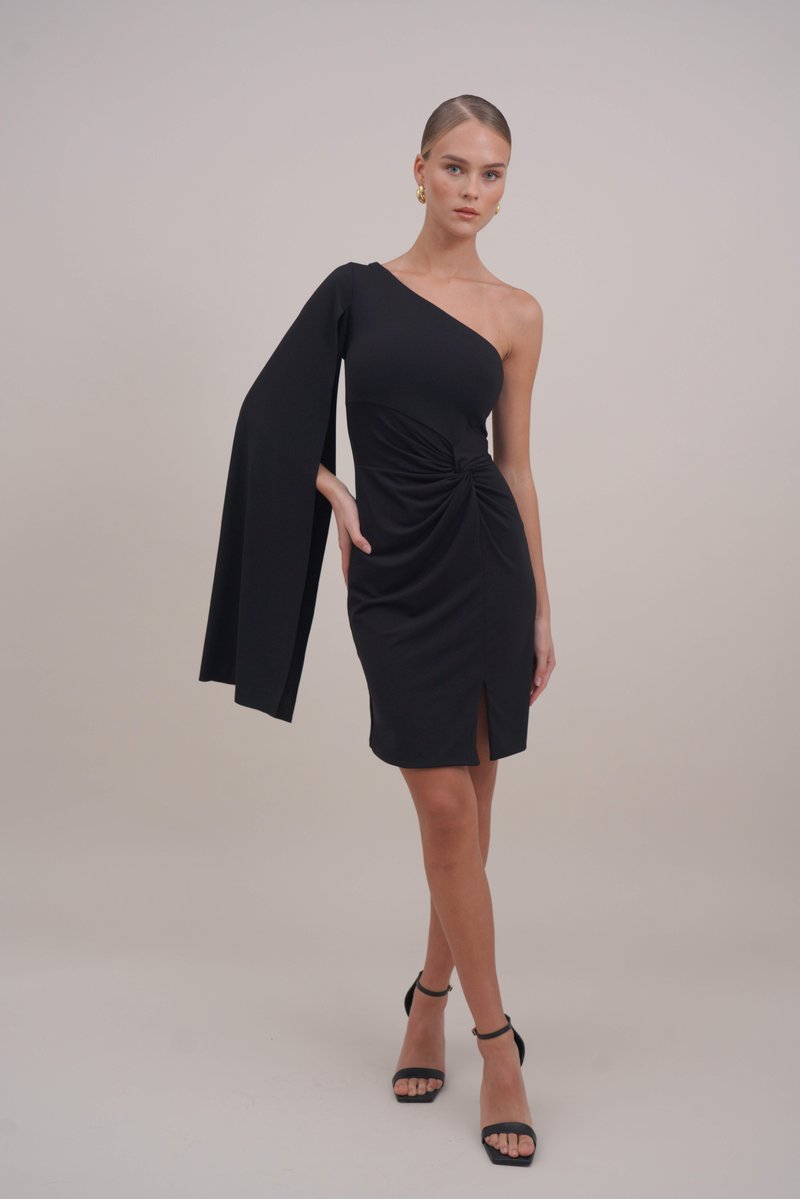 Μαύρο, φόρεμα με έναν ώμο και ρέον μανίκι, με συγκεντρωμένη υφή στη μέση και άνοιγμα στο πλάι. Φοριέται με μαύρες ψηλοτάκουνες σαμπάς.