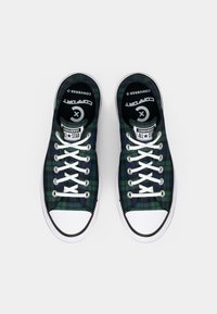 Zelené a námořnické kostičkované plátěné boty s bílými tkaničkami a gumovými podrážkami. Mají černou podšívku a logo Converse na jazyku.