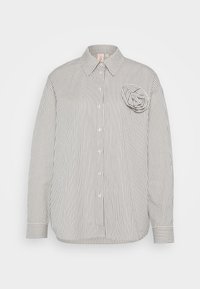 White long-sleeve button-up shirt with thin vertical black stripes and a fabric flower detail on the left chest.