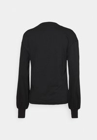 Sort langærmet skjorte med rynkede manchetter, vist bagfra mod en ensfarvet lys baggrund.