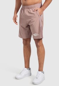Herrpastellrosa atletiska shorts med elastisk midja, sidofickor och en vit logotypdetalj. Slät tygtextur.