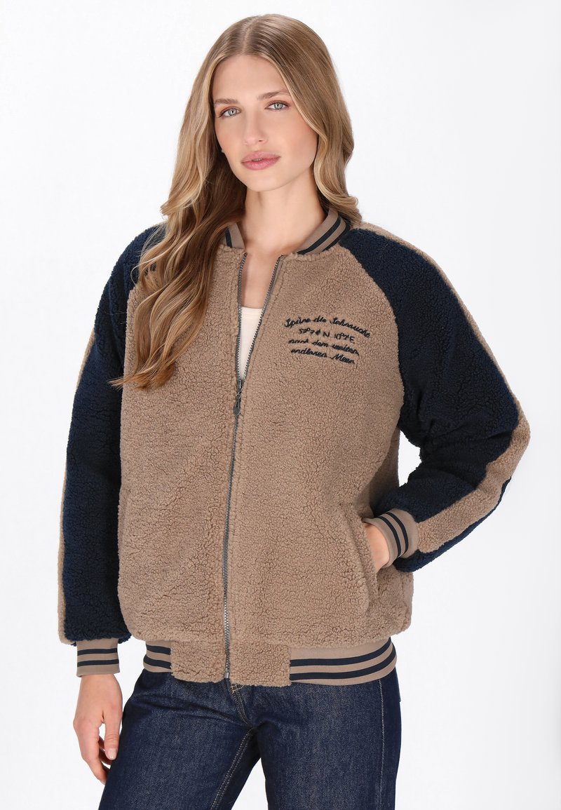 Brun og marineblå fleecejakke med lynlås foran, ribbede manchetter og broderet tekst. Blød tekstur med en afslappet pasform. Stribet halskrave.