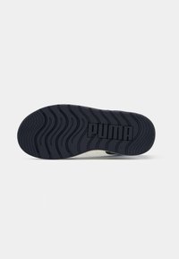 Semelle de basket Puma en caoutchouc bleu foncé avec un motif de grip texturé. Présente le logo en relief de manière bien visible au niveau du talon.