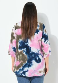 Camisa de tie-dye multicolor con un corte holgado, con tonos de rosa, azul y marrón. Tela texturada y mangas tres cuartos.