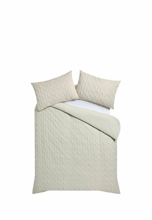 Beige strukturiertes gesteppte Tagesdecke mit zwei passenden Kissen auf einem weißen Spannbettlaken, auf einem Bett arrangiert.