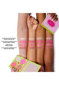 Palette features bright pink and blush shades, with a shimmery highlight. Arms show swatches of various colors against diverse skin tones.