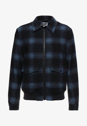 Schwarze und blaue karierten Jacke mit Reißverschluss vorne, zwei Brusttaschen mit Klappen und gerippten Bündchen sowie Saum. Hergestellt aus gewebtem Stoff.