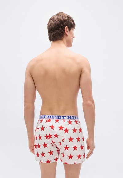 Ανδρικά μποξεράκια από λευκό βαμβάκι με κόκκινους αστέρες, με μπλε ελαστική μέση που επαναλαμβάνει το κείμενο "HOT". Εμφανίζεται η πίσω όψη.