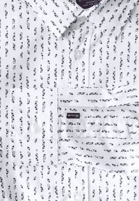 Bílá košile s černým geometrickým trojúhelníkovým vzorem. Obsahuje knoflíkový límec, přední knoflíky a štítek s označením "STREET ONE MEN." Bavlněný materiál.