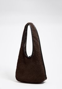 Bolso tejido marrón con cuerpo suave y texturizado, asa grande recortada y ribete negro contrastante en la parte superior.