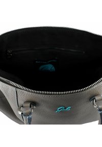 Bolso de mano de cuero gris con superficie texturizada, cierre superior con cremallera, bolsillo interior con cremallera y logo azul claro. Forrado con tela negra.