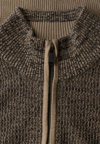 Knit zip-up sweater with a textured pattern, featuring a high collar in shades of brown and beige. Metal zipper with a raised pull tab.