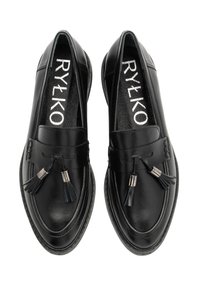 Svarta läderloafers med tofsar på toppen och märket "RYŁKO" synligt inuti, sedd ovanifrån mot vit bakgrund.